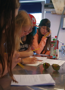 leerlingen middelbare school werken in groepjes aan diverse opdrachten aan lesbrief gezonde voeding