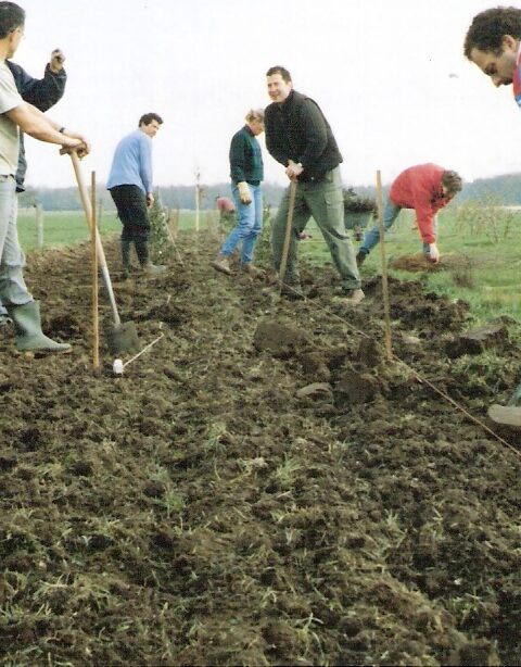 Een groep mensen is bezig plantmateriaal te planten voor heggen en houtsingels op Sprankenhof (2006)